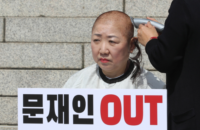 자유한국당 박인숙 의원이 11일 오전 국회 본청 앞 계단에서 조국 법무부 장관 해임을 요구하며 삭발하고 있다. 연합뉴스