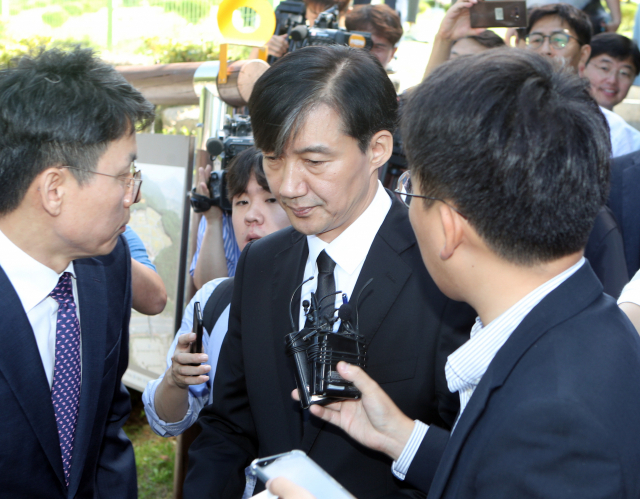 조국 법무부 장관이 14일 오전 부산 기장군 부산추모공원에 안장된 고 김홍영 전 검사 묘소에 참배한 뒤 차량에 탑승하고 있다. 김 전 검사는 서울남부지검 형사부에 근무하던 2016년 5월 업무 스트레스와 직무 압박감을 토로하는 내용의 유서를 남기고 서른셋의 나이에 목숨을 끊었다. 연합뉴스