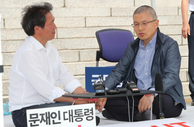 자유한국당 황교안 대표(오른쪽)가 17일 국회 앞에서 단식 농성중인 이학재 의원을 격려하고 있다. 연합뉴스