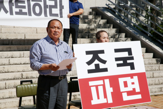 18일 경북 포항시청 앞 광장에서 김순견 전 경북도 경제부지사가 부인 박재옥씨와 함께 조국 법무부 장관 사퇴를 촉구하며 삭발한 뒤 성명서를 읽고 있다. 연합뉴스