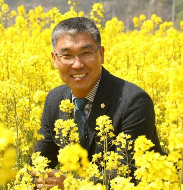 공경식 울릉군의회 의원이 울릉군 서면 태하리 유채꽃밭에서 환하게 웃고 있다. 공경식 군의원 제공