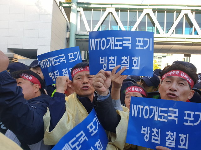 25일 오전 외교부 정문 앞에서 농민단체 회원들이 WTO 개도국 포기 방침 철회를 요구하는 집회를 하고 있다. 연합뉴스