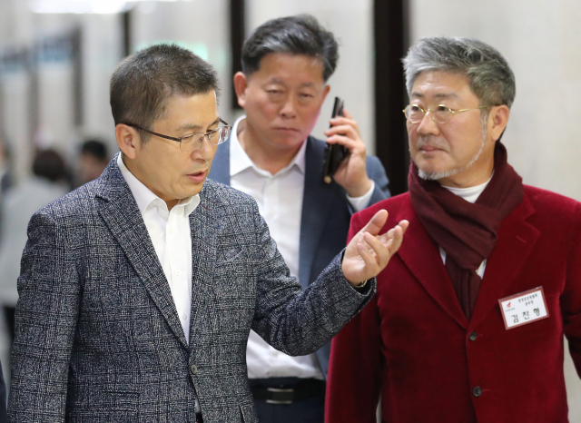 자유한국당 황교안 대표(왼쪽)가 13일 오전 국회에서 열린 당 홍보위원회 임명장 수여식에 참석하며 김찬형 홍보본부장과 대화하고 있다. 연합뉴스