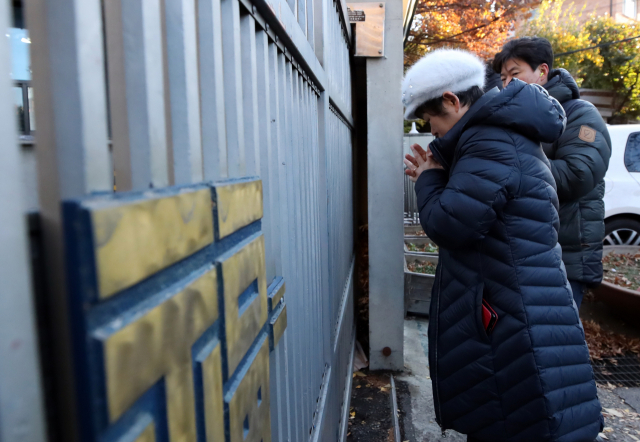 2019 대입 수학능력시험일인 14일 오전 서울 종로구 경복고 앞에서 한 수험생 학부모가 고사장을 향해 서서 기도를 하고 있다. 연합뉴스