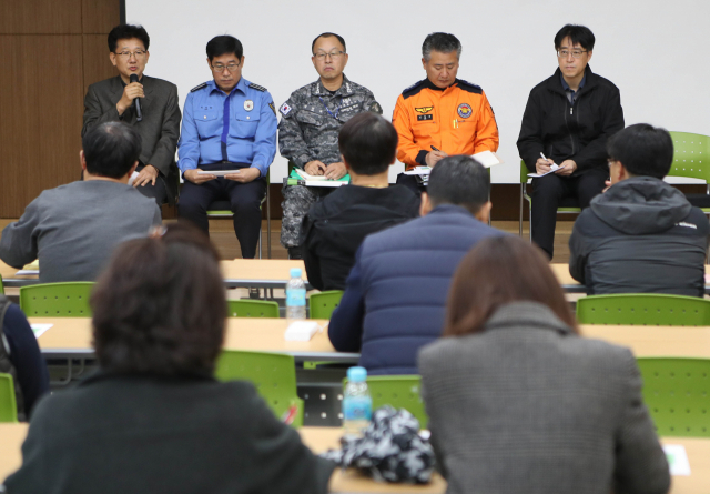 18일 오전 대구 달성군 강서소방서 3층에 마련된 독도 소방구조헬기 추락사고 범정부 현장 수습지원단 브리핑실에서 지원단 관계자들이 추락 헬기 탑승원 가족들에게 수색 상황에 대해 브리핑하고 있다. 연합뉴스