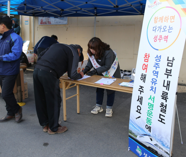 경북 성주군 벽진면사무소를 찾은 주민들이 남부내륙철도 성주역 유치를 요구하는 서명을 하고 있다. 성주군 제공