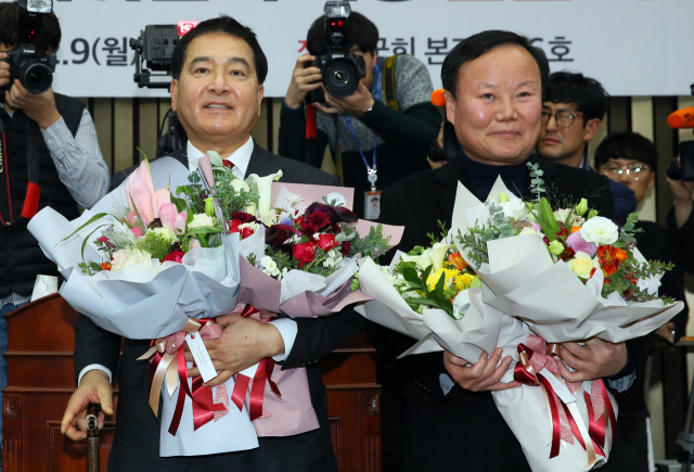 자유한국당 새 원내대표에 선출된 심재철 의원(왼쪽)과 신임 김재원 정책위의장이 9일 국회에서 열린 의원총회에서 축하 꽃다발을 받고 기뻐하고 있다. 연합뉴스