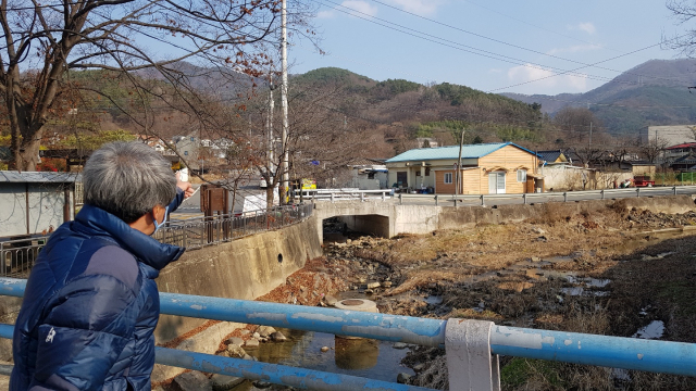 대구 달성군 상원리 주민이 달성폐광산 쪽을 가리키고 있다. 채원영 기자.