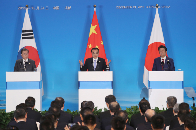 한중일 정상회담을 마친 리커창 중국 총리가 24일(현지시간) 쓰촨성 청두 세기성 국제회의센터에서 공동 언론발표를 하고 있다. 왼쪽부터 문재인 대통령, 리 중국 총리, 아베 일본 총리. 연합뉴스