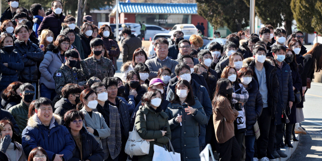 육군 50사단 신병교육대대 앞에서 마스크를 쓴 입영 대상자 가족들이 훈련병으로 입영하는 아들의 입소를 지켜보고 있다. 지난 4일 열린 새해 첫 현역병 입소식은 신종코로나바이러스 감염증 예방을 위해 별도 행사 없이 가족의 출입도 통제됐다. 김영진 기자 kyjmaeil@imaeil.com