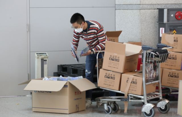 4일 오후 인천국제공항에서 공항 이용객이 마스크가 든 수레를 운반하고 있다. 연합뉴스