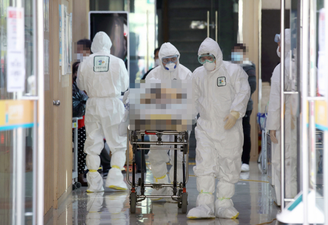 국내 18번째 신종 코로나바이러스 감염증 확진 환자가 발생한 광주21세기병원에서 5일 오후 질병관리본부 관계자들이 병원 내에 격리됐던 일반 환자들을 다른 격리장소로 이송시키고 있다. 연합뉴스