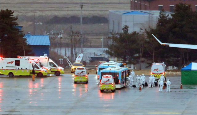 12일 오전 중국 우한 교민을 태운 3차 전세기가 김포공항에 도착해 관계자들의 안내를 받은 교민들이 버스에 탑승하고 있다. 연합뉴스