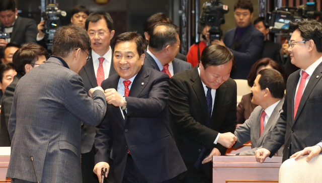 자유한국당 심재철 원내대표와 김재원 정책위의장이 13일 오전 서울 여의도 국회에서 열린 의원총회에 참석하며 의원들과 주먹인사를 하고 있다. 연합뉴스