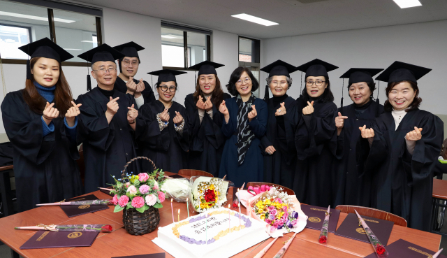 영진전문대 사회복지과 산업체위탁반 졸업생들이 최근 졸업기념 파티를 열고 이애재 지도교수(왼쪽서 여섯 번째)와 기념 촬영을 하며 즐거워하는 모습. 영진전문대 제공