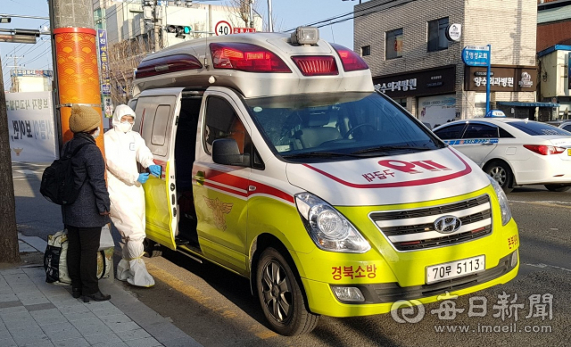 영천시 보건당국이 코로나19 확진자의 병원 이송과정에서 전담관리반원 없이 운전기사 1명만을 보내 논란을 키우고 있다. 사진은 22일 오후 119차량 운전자가 확진자를 태우는 현장에 전담관리반원은 보이지 않고 있다. 독자 제공