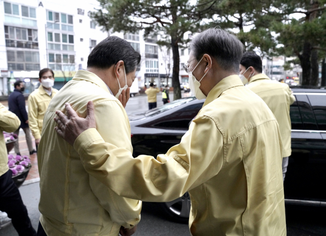 문재인 대통령이 25일 대구광역시 남구청에서 코로나19 확산에 따른 취약계층 복지전달체계 현황을 보고를 받은 후 조재구 남구청장을 위로하고 있다. 조 구청장은 현황보고 때 눈물을 보였다. 연합뉴스