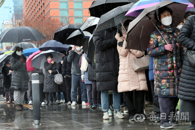 비가 내린 지난 28일 오후 마스크를 구입하려 대구 수성우체국을 찾은 시민들이 번호표를 받아 기다리리고 있다. 이날 수성우체국에서는 준비한 420명분 물량이 동나 되돌아가는 시민도 많았다. 김태형 선임기자 thk@imaeil.com