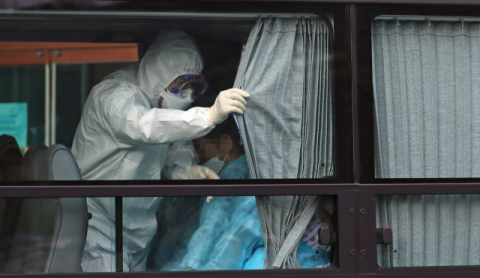 27일 오후 경북 청도 대남병원에서 서울 국립정신건강센터로 이동하는 환자 이송 버스 안에서 한 의료진이 커튼을 치고 있다. 연합뉴스