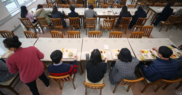 27일 낮 대구시 수성구 대구시교육청 구내식당에서 직원들이 마주 앉지 않고 말없이 점심을 먹고 있다. 대구시교육청은 신종 코로나바이러스 감염증 확산을 막기 위해 직원들에게 구내식당에서 식사 때 손 소독, 대화하지 않기와 마주 보며 앉지 않도록 했다. 연합뉴스