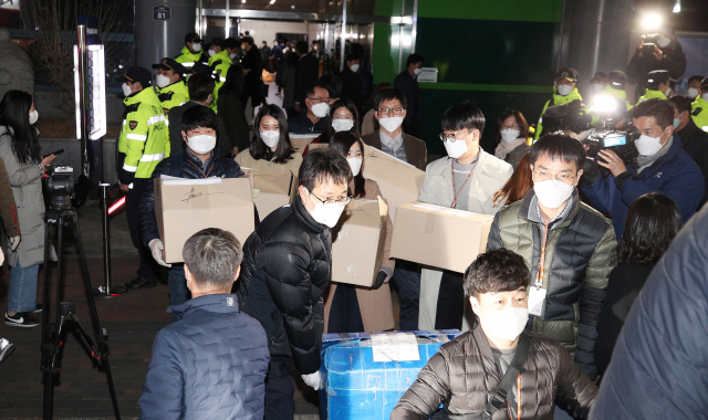 신천지 대구교회 역학조사를 위해 행정조사가 실시된 지난 12일 남구 대명동 신천지 대구교회에서 대구시와 경찰 관계자들이 확보한 서류와 물품 등을 박스에 담아 옮기고 있다. 김영진 기자 kyjmaeil@imaeil.com