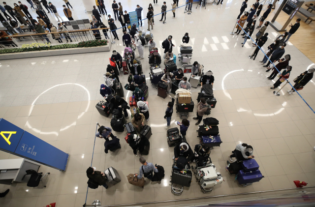 유럽에서 국내로 들어오는 입국자에 대한 검역 절차가 강화된 22일 오후 인천국제공항 2터미널에서 영국 런던에서 여객기를 타고 입국한 승객들이 진단 검사를 받는 곳으로 이동하기 위해 대기하고 있다. 연합뉴스