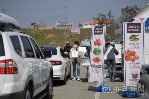 지난 21일 경북 영덕군 강구면 삼사해상공원에서 열린 드라이브 스루 농수산물 소비촉진 행사에서 관광객들이 차에 탄 채 농수산물을 구매하고 있다. 영덕군 제공