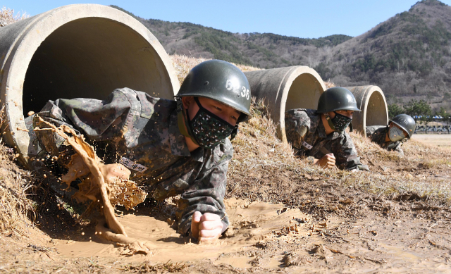 13일 경남 창원시 진해구 해군교육사령부 야전교육대대에서 마스크를 착용한 664기 해군병이 각개전투 훈련을 하고 있다. 연합뉴스