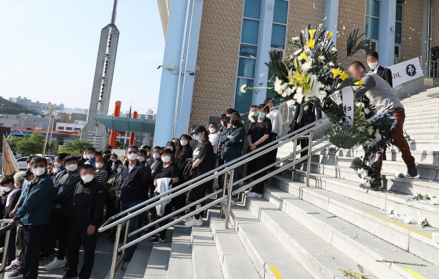 4일 오후 경기도 이천시 서희청소년문화센터에 마련된 이천 물류창고 공사장 화재 합동분향소에서 열린 유가족 기자회견에서 한 유가족이 한익스프레스에서 보낸 조화를 바닥에 던지고 있다. 연합뉴스