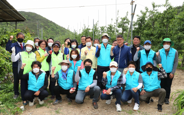 이철우 경북도지사와 농림축산식품부, 경북도, 의성군 공무원, 농협경북본부 직원 등은 의성군 옥산면에서 과수 열매솎기를 마치고, 경북 농업 발전을 위한 파이팅을 외치고 있다. 의성군 제공