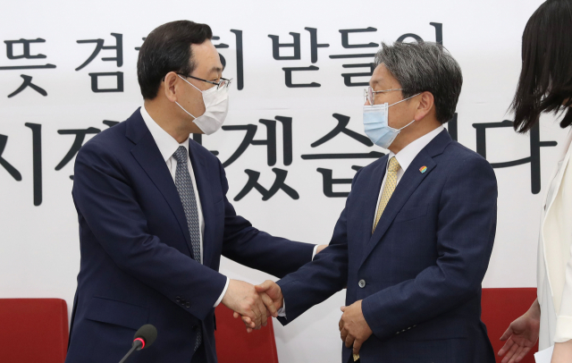 미래통합당 주호영 원내대표(왼쪽)와 강기정 청와대 정무수석이 15일 오전 국회 미래통합당 원내대표실에서 만나 악수하고 있다. 연합뉴스