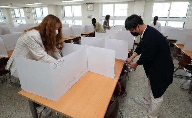 지난 13일 오전 서울 성동구 덕수고등학교에서 영양사 및 교사 등이 급식실에 칸막이를 설치하고 있다. 연합뉴스