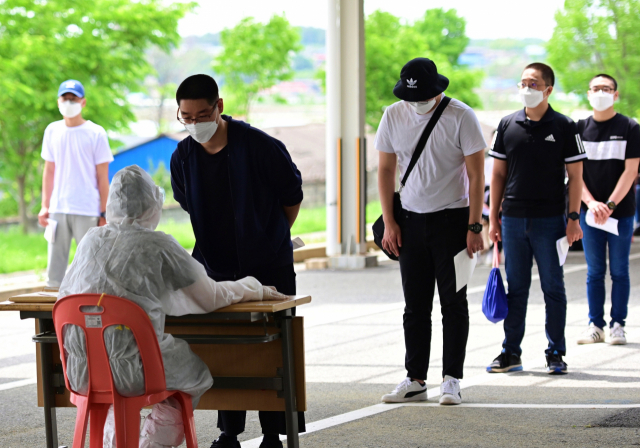 지난 18일 육군훈련소로 입소한 입영 장정들이 PCR검사 전수조사를 위해 간이문진표를 작성하고 있다. 육군 제공