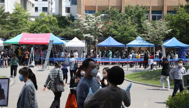 지난 29일 오전 서울 영등포보건소 선별진료소에서 시민들이 진료를 받기 위해 줄을 서 있다. 연합뉴스