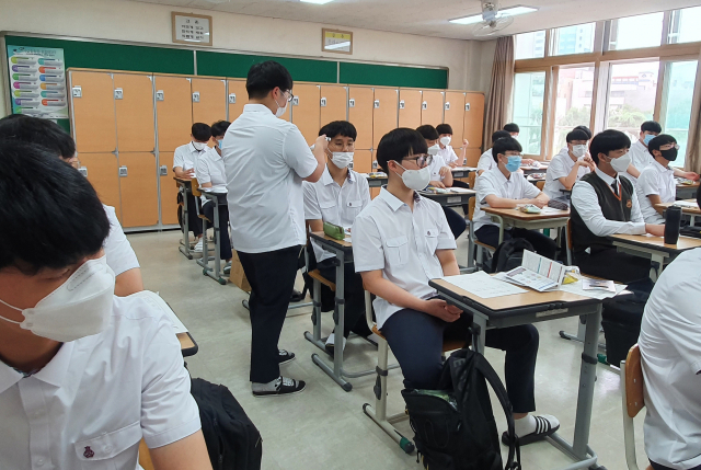 3일 오전 대구 달성고등학교 1학년 교실에서 감염병 예방도우미 학생이 체온계로 같은 반 학우의 발열 체크를 하고 있다. 이연정 기자