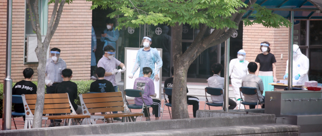 8일 서울 중랑구 원묵고등학교에 마련된 선별진료소에서 이 학교 학생, 교직원들이 신종 코로나바이러스 감염증(코로나19) 검사를 받기 위해 차례를 기다리고 있다. 전날 이 학교 3학년 학생이 코로나19에 감염된 것으로 확인됨에 따라 원묵고는 등교 중지와 함께 학생·교직원에 대한 전수조사에 들어갔다. 우선 이날부터 오는 10일까지 전 학년이 온라인 수업으로 전환한다. 연합뉴스