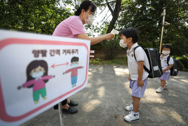 대구지역 어린이집이 신종 코로나바이러스 감염증(코로나19) 사태로 휴원 후 122일 만에 정상 등원을 시작한 22일 오전. 대구시 중구 대구 백합어린이집에서 어린이들이 거리 두기를 실천하며 교실로 가기전 발열체크를 하고 있다. 연합뉴스