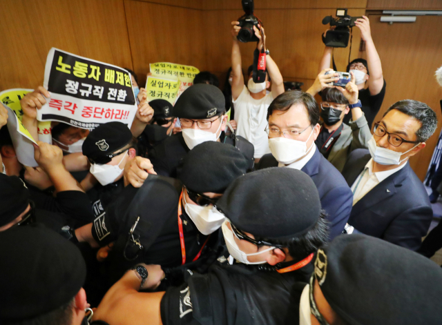 22일 인천국제공항 제1여객터미널에서 보안검색 노동자 정규직화 관련 브리핑을 마친 구본환 인천국제공항공사 사장이 브리핑실을 나와 엘리베이터로 이동하던 중 직원들의 거센 항의를 받고 있다. 연합뉴스