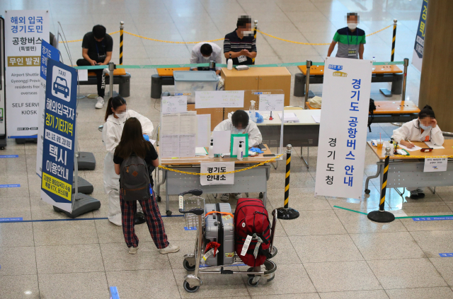 22일 오후 인천국제공항 제1여객터미널 입국장에서 한 입국자가 방역 관계자로부터 설명을 듣고 있다. 연합뉴스