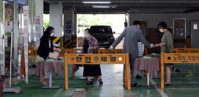 지난 5일 오전 광주 북구 한 교회에서 관계자가 예배에 참석하려는 신도의 체온을 확인하고 있다. 광주시와 각 자치구는 신종 코로나바이러스 감염증(코로나19) 확산에 따른 사회적 거리두기 2단계 격상으로 종교시설 방역지침 준수 여부를 점검했다. 연합뉴스