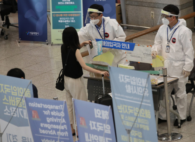 지난 7일 오후 인천국제공항 1터미널 입국장에서 입국자들이 교통편 등의 안내를 받고 있다. 정부는 검역이나 격리 단계에서 모두 걸러지기 때문에 해외유입 감염이 지역사회로 확산할 가능성은 크지 않다고 밝혔다. 연합뉴스