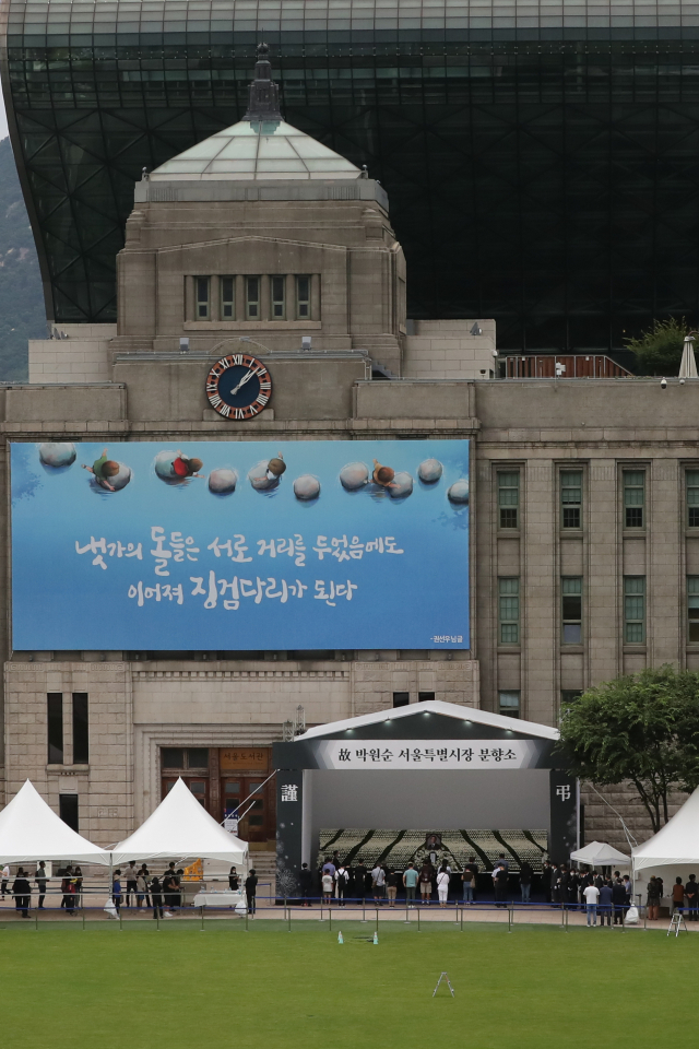 12일 서울광장에 마련된 고 박원순 서울시장 분향소를 찾은 시민들이 묵념하고 있다. 연합뉴스