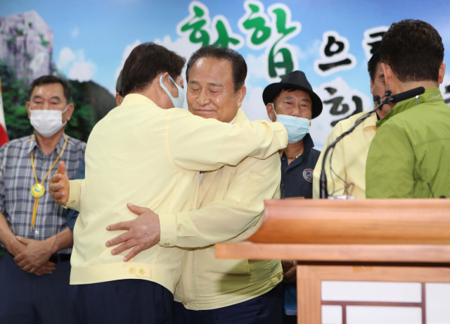 지난달 30일 오후 경북 군위군청에서 김영만 군위군수가 대구통합 신공항 이전지를 공동후보지로 신청할 것을 조건부 합의했다고 밝힌 후 권영진 대구시장과 껴안고 있다. 연합뉴스