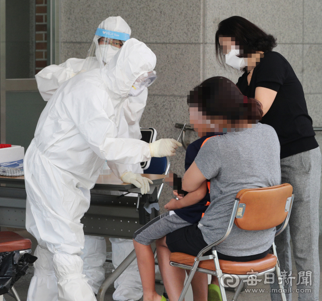 21일 대구 한 초등학교 병설유치원에서 원생 1명이 코로나19 확진자가 발생한 가운데 한 재원생이 보호자와 함께 코로나19 검사를 받고 있다. 성일권 기자 sungig@imaeil.com