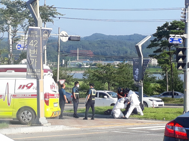 안동시 태화동 어가골 입구 도로변에서 한 남성이 경찰과 119방역진들에게 둘러싸여 검체 채취를 받고 있다. 독자 제공