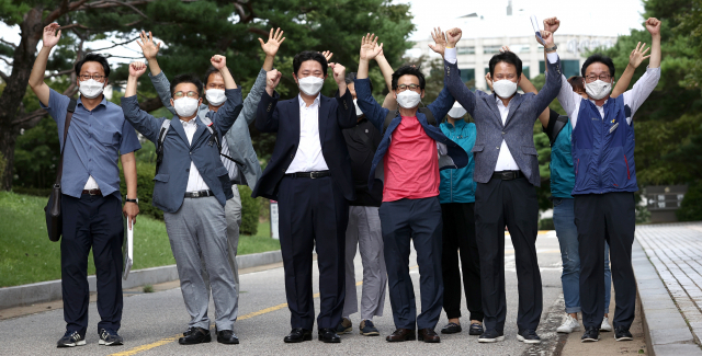 권정오 전국교직원노동조합(전교조) 위원장(앞줄 오른쪽 두 번째)과 조합원들이 3일 오후 서울 서초동 대법원에서 열린 법외노조 통보 처분 취소 소송 상고심 선고를 마친 후 만세하고 있다. 연합뉴스