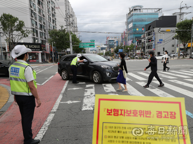 7일 오후 대구 서구 남평리네거리 횡단보도에서 서부경찰서 교통경찰관들이 보행자 신호등을 무시한 채 진입한 차량을 멈춰 세운 뒤 