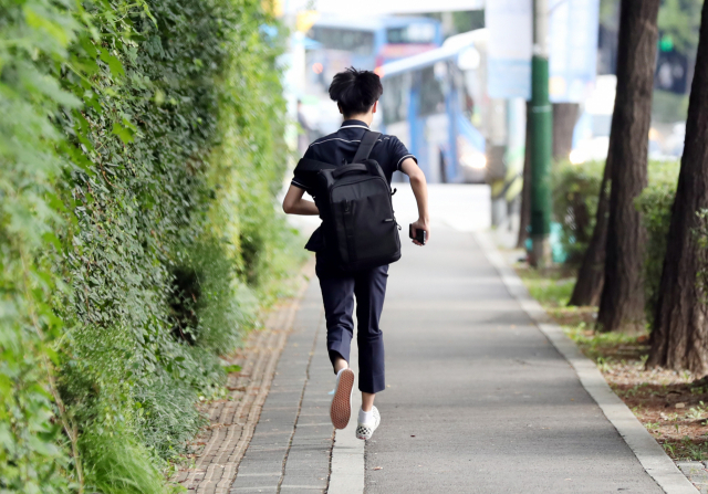 수도권 지역 유·초·중·고 학생들의 등교가 재개된 21일 오전 인천시 남동구 한 행로에서 한 학생이 학교를 향해 달리고 있다. 이날 등교는 지난달 25일 신종 코로나바이러스 감염증(코로나19) 재유행이 거세져 수도권 지역 학교들이 전면 원격 수업에 들어간 지 27일 만에 이뤄졌다. 연합뉴스