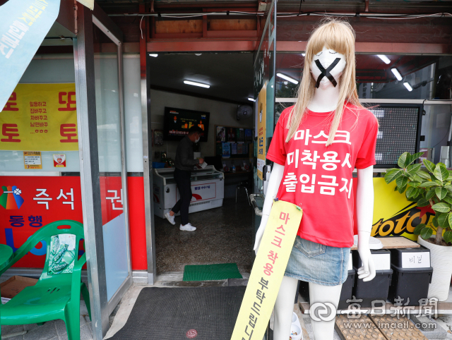 지난 5일 대구 시내 한 복권 판매점 앞에 마스크를 씌운 마네킹이 놓여 눈길을 끈다. 김영진 기자 kyjmaeil@imaeil.com