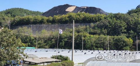 김경구 성주군 용계리 이장 집(태극기 있는 곳) 뒷길에서 바라본 A산업 전면 모습. 순환골재 더미가 옆 산봉우리보다 더 높다. 이영욱 기자